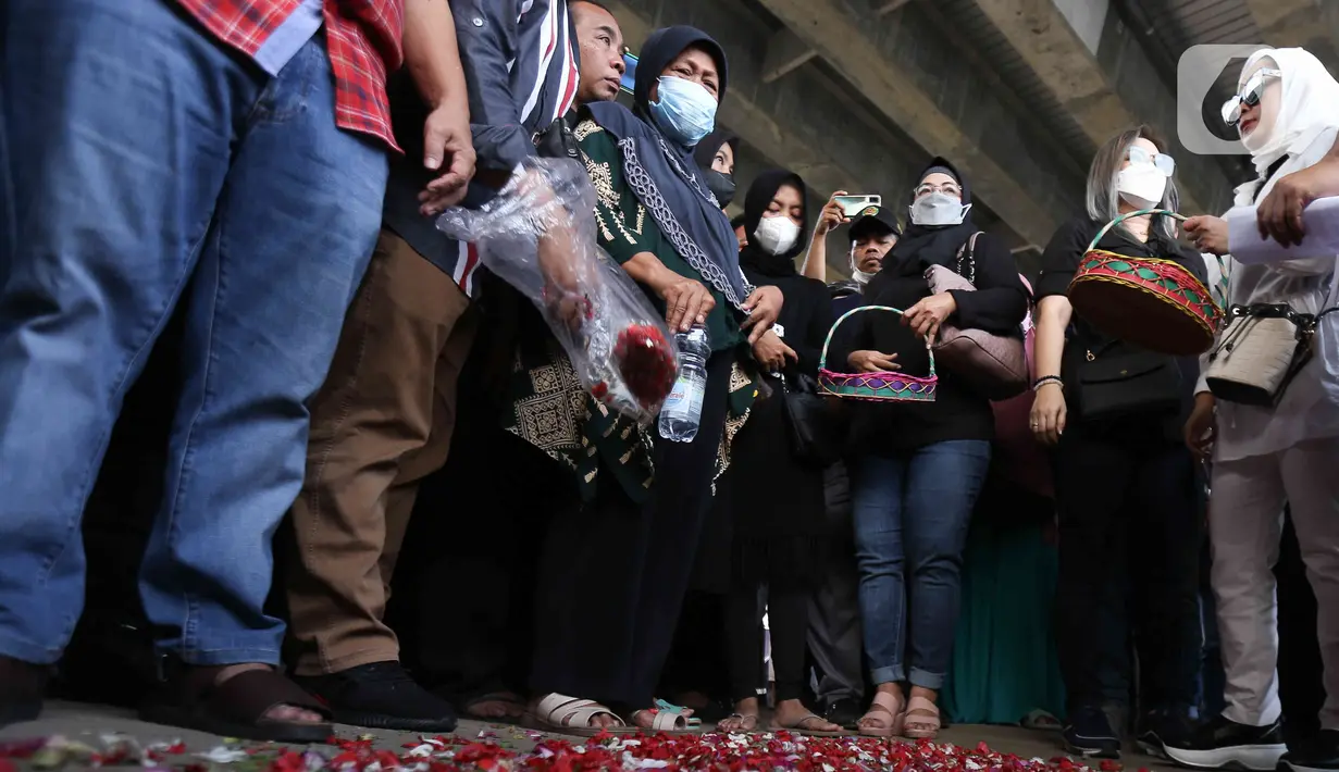 Sejumlah kerabat korban dan warga melakukan tabur bunga di lokasi kecelakaan maut di Jalan Transyogi, Cibubur, Bekasi, Jawa Barat, Rabu (20/7/2022). Aksi tabur bunga tersebut sebagai bentuk rasa duka cita atas meninggalnya 11 orang korban kecelakaan maut di kawasan tersebut. (Liputan6.com/Herman Zakharia)