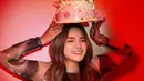Nathalie pamer foto cantik dan estetik dengan kue ulang tahun. Latar belakang merah mendominasi sesi foto tersebut. [Instagram.com/nathalieholscher]