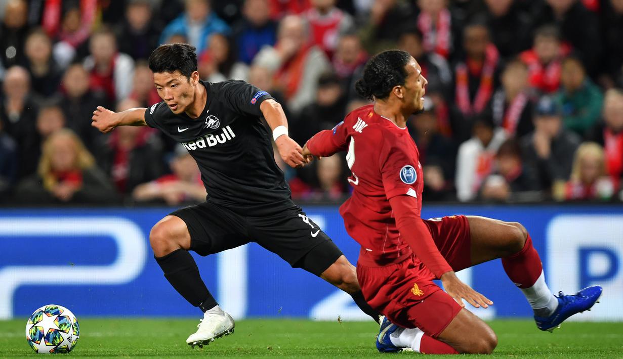 Gelandang Salzburg, Hwang Hee-Chan, mengocek bek Liverpool, Virgil Van Dijk pada laga Liga Champions di Stadion Anfield, Liverpool, Rabu (2/10). Liverpool menang 4-3 atas Salzburg. (AFP/Paul Ellis)