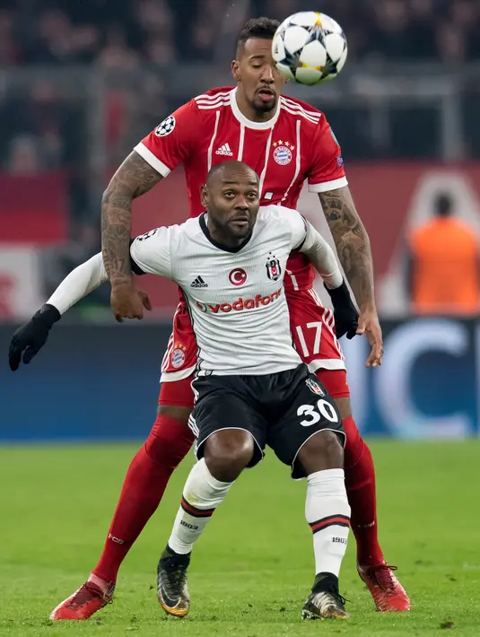 Pemain Bayern Munchen, Jerome Boateng berebut bola dengan pemain Besiktas, Vagner Love pada pertandingan pertama babak 16 besar Liga Champions di Allianz Arena, Selasa (20/2).  Bayern melumat Besiktas lima gol tanpa balas. (Matthias Balk/dpa via AP)