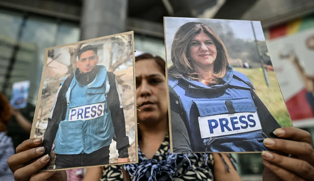 Sejumlah warga Palestina turut berduka atas kematian jurnalis tersebut. Tampak dalam foto, seorang pekerja media pemerintah memegang potret jurnalis Palestina yang telah meninggal selama demonstrasi di depan gedung PBB di Caracas pada 11 Agustus 2025. (Juan BARRETO/AFP)