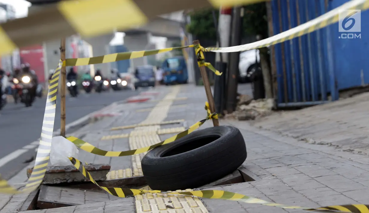 Sebuah ban bekas diletakkan sebagai tanda penutup trotoar yang rusak di kawasan Jalan RS Fatmawati, Jakarta, Selasa (14/7/2019). Dua buah penutup trotoar di Jalan RS Fatmawati rusak parah, kondisi ini membahayakan pejalan kaki, terutama pada malam hari. (Liputan6.com/Helmi Fithriansyah)