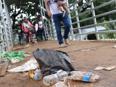 Kemasan botol air mineral berceceran di koridor Jembatan Penyebrangan Orang (JPO) Jalan Medan Merdeka Barat, Jakarta, Selasa (1/1). Pasca malam perayaan pergantian tahun JPO Medan Merdeka Barat masih tampak kotor. (Liputan6.com/Helmi Fithriansyah)