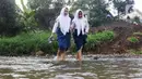 Ketika menyeberangi sungai, para siswa harus berjalan hati-hati. (Liputan6.com/Herman Zakharia)