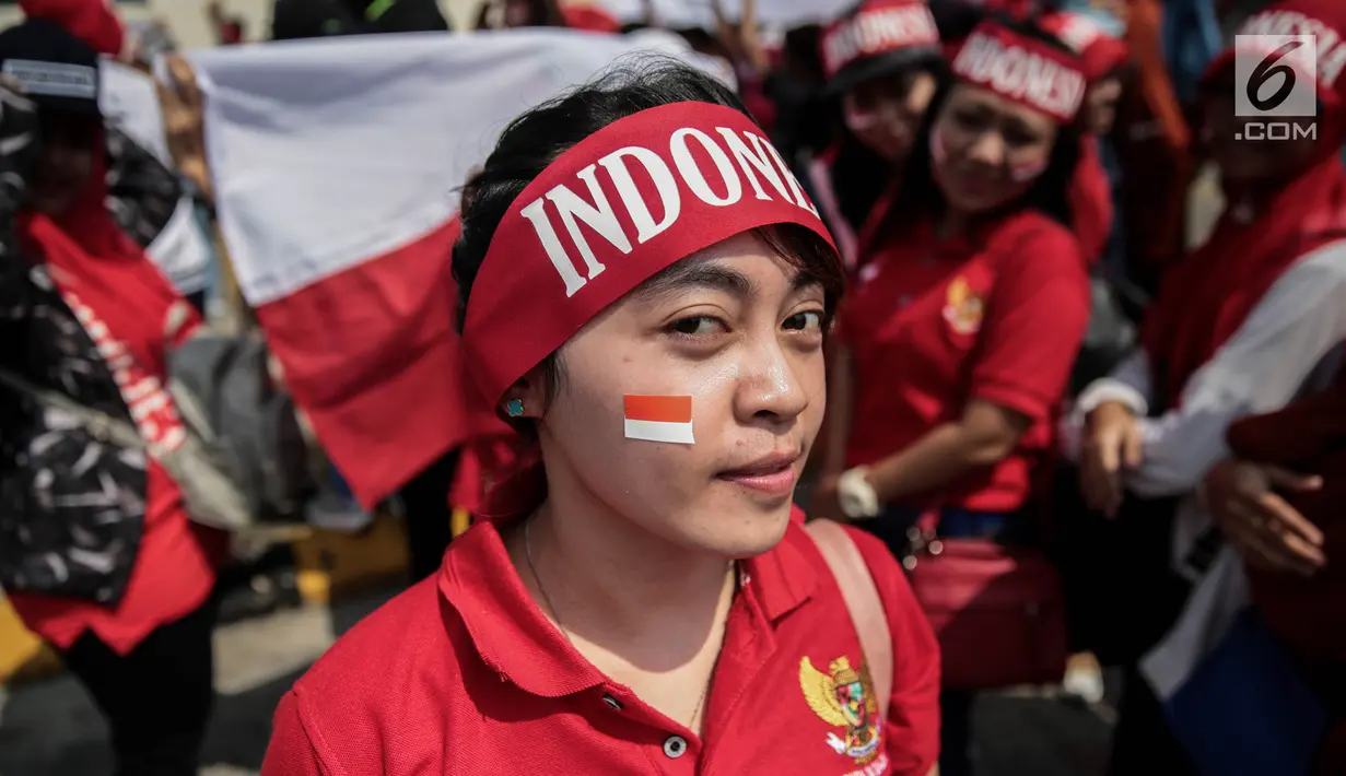 Seorang suporter Garuda Muda mengenakan ikat kepala untuk mendukung Timnas Indonesia U-22 pada laga lanjutan grup B SEA Games 2017 melawan Timor Leste, Minggu (20/8). Indonesia menang 1-0 atas Timor Leste. (Liputan6.com/Faizal Fanani)