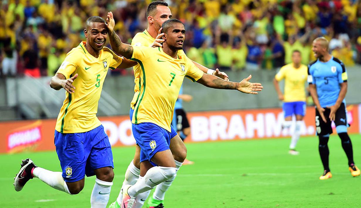 Gelandang Brasil, Douglas Costa, merayakan gol yang dicetaknya ke gawang Uruguay pada kualifikasi Piala Dunia 2018 di Recife, Brasil, Sabtu (26/3/2016) pagi WIB. Brasil menguasai jalannya laga dengan penguasaan bola 68 persen. (AFP/Christophe Simon)