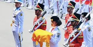 Bak Cinderella, sepatu Lilly tiba-tiba copot usai membawa bendera ke tengah lapangan dan hendak menghadap Presiden Jokowi. Alhasil ia menghadap Jokowi dengan membawa baki tanpa sepatu di kaki kirinya. Ia pun harus berjalan kembali mengelilingi lapangan upacara tanpa sepatu, namun ia profesional tetap bersikap tenang. [Instagram/Jokowi]