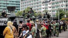 Tentara berdiri di atas alat utama sistem senjata (alutsista) saat perayaan HUT ke-77 TNI di Bundaran HI, Jakarta, Rabu (5/10/2022). Kegiatan yang diikuti oleh seluruh kesatuan jajaran TNI ini dalam rangka menyambut HUT ke-77 TNI. (Liputan6.com/Faizal Fanani)
