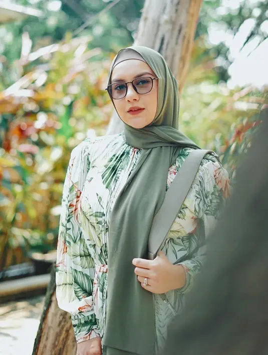 Tampil santun dalam balutan gaun bernuansa hijau yang feminin, gaya fashion Irish Bella semakin menarik dengan kacamata hitamnya. (Liputan6.com/IG/@_irishbella_)