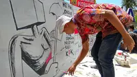 Unek-unek para seniman mural yang tergabung dalam Komunitas Tikar Pandan tumpah ruah di atas tripleks yang disandarkan di tembok Taman Bustanulsalatin (Liputan6.com/Rino Abonita)