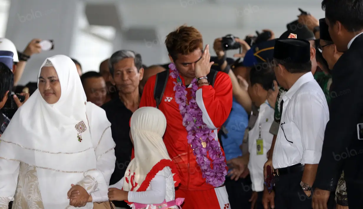 Tontowi Ahmad terlihat mengusap air mata saat bertemu keluarganya di Terminal 3, Bandara Soekarno-Hatta, Banten, Selasa (23/8/2016). (Bola.com/Nicklas Hanoatubun)