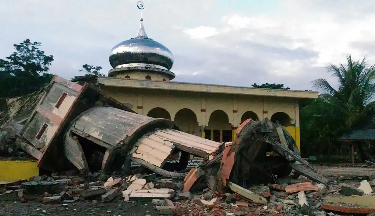 Sebuah menara masjid roboh menyusul gempa 6,4 SR yang mengguncang Kabupaten Pidie Jaya, Aceh, Rabu (7/12). Empat orang dikabarkan meninggal dunia dan sekitar 30 warga mengalami luka-luka akibat tertimpa bangunan roboh. (Zian Muttaqien/AFP)