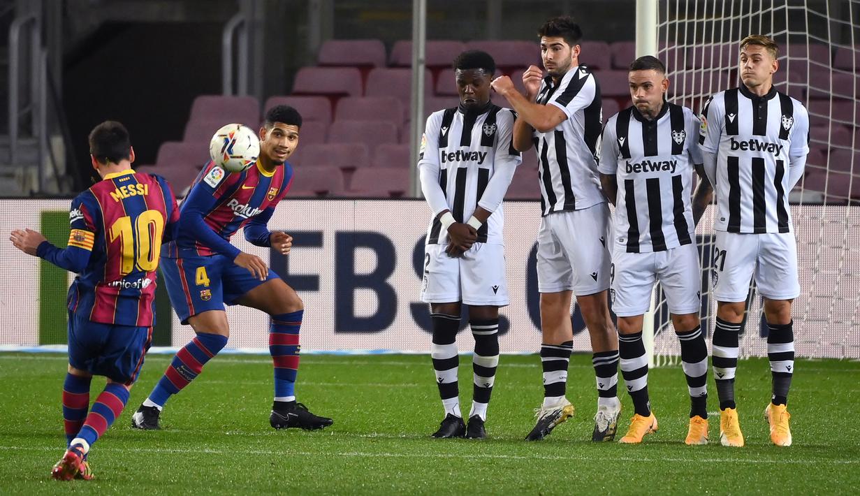 Striker Barcelona, Lionel Messi, melepaskan tendangan bebas saat melawan Levante pada laga Liga Spanyol di Stadion Camp Nou, Senin (14/12/2020). Barcelona menang dengan skor 1-0. (AFP/Lluis Gene)