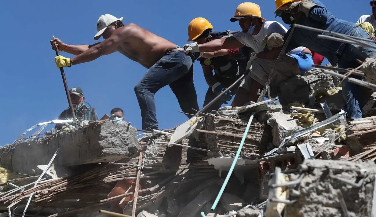 Warga dan petugas penyelamat mencari di antara puing-puing setelah gempa bumi melanda Cali, Kolombia, pada hari Senin, 10 Agustus 2026. (Foto AP/Santiago Saldarriaga)