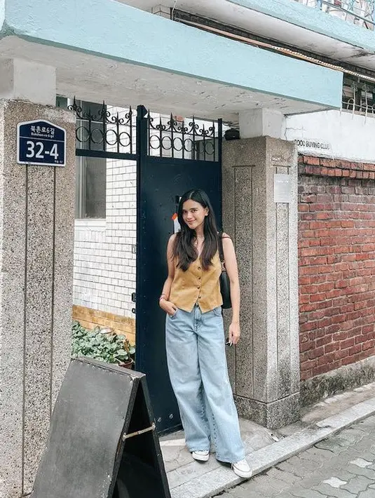 Audi Marissa juga berkunjung ke Korea Selatan, ia mengenakan atasan vest coklat dipadukan celana denim dan sneakersnya. [@audimarissa]