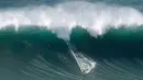 Peselancar unjuk kebolehan saat menaklukkan ombak besar di Praia do Norte atau Pantai Utara, Nazare, Portugal, Rabu (20/11/2019). Perairan Praia do Norte menjadi tempat uji nyali para peselancar dunia karena ombaknya yang bisa mencapai 30 meter. (AP Photo/Armando Franca)