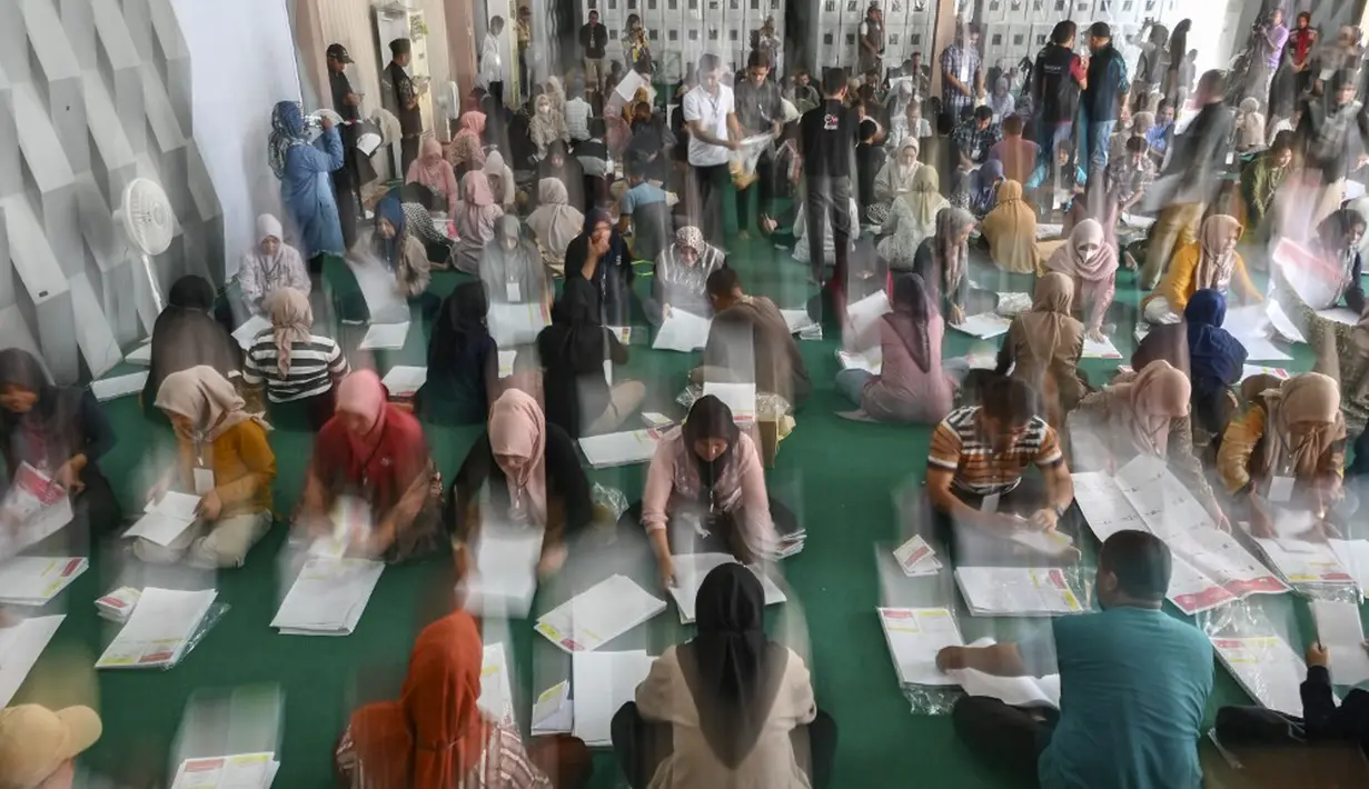 Para pekerja menyiapkan surat suara jelang pemilihan umum (Pemilu) 2024 pada 14 Februari mendatang di Banda Aceh, Aceh, Minggu (7/1/2024). (CHAIDEER MAHYUDDIN/AFP)