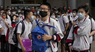 Siswa yang mengenakan masker bersiap memasuki sekolah untuk hari pertama ujian masuk perguruan tinggi nasional China, atau dikenal gaokao, di Beijing, Selasa (7/6/2022). Lebih dari 11 juta siswa sekolah menengah di seluruh China akan mengikuti ujian masuk perguruan tinggi tahunan setelah negara itu baru saja mengatasi wabah COVID-19 yang parah di Shanghai dan Beijing (AP Photo/Andy Wong)