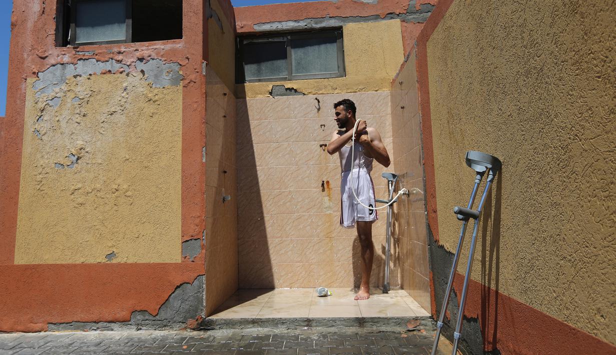 Pemuda Palestina mandi setelah mengambil bagian dalam sesi pelatihan renang di bawah instruksi Majdi al-Tatar di Kota Gaza (30/7/2019). Tatar melatih warga Palestina yang diamputasi untuk membantu mereka mempertahankan aktivitas fisik. (AFP Photo/Mahmud Hams)