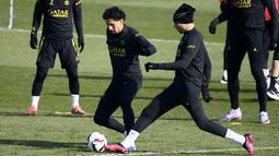 Bek PSG Achraf Hakimi (kedua kanan) memainkan bola dengan Marquinhos selama sesi latihan jelang menjamu Nantes pada Liga Prancis, di tempat latihan klub di Saint-Germain-en-Laye, sebelah barat Paris, Jumat (3/3/2023). PSG meraih 2 kemenangan beruntun setelah mengalami 3 kekalahan di 3 kompetisi berbeda. (Photo by FRANCK FIFE / AFP)