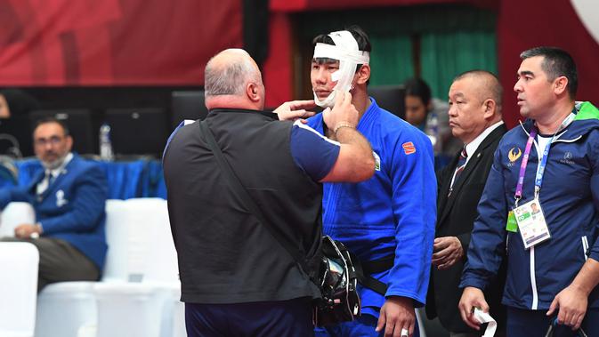 Pejudo putra Uzbekistan, Bekmurod Oltiboev mendapatkan perawatan medis saat melawan Takeshi Ojitani asal Jepang di permpat final judo Asian Games 2018 di Jakarta, Jumat (31/8). (ANTARA FOTO/INASGOC/Bram Selo Agung/18)