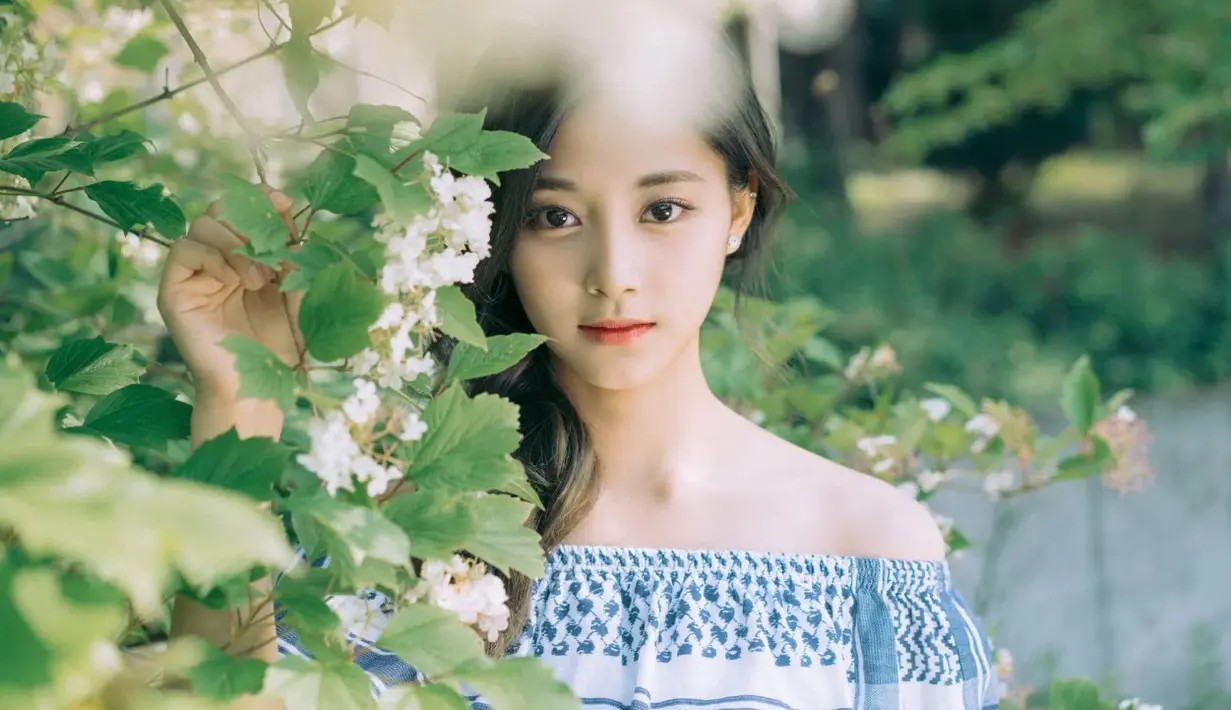 Matanya yang bulat membuat Tzuyu TWICE semakin terlihat cantik menawan. Apalagi kecantikannya dipadupadankan dengan bunga yang sedang mekar, benar-benar sempurna. (Foto: koreaboo.com)