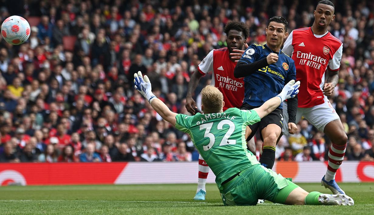 Striker Manchester United, Cristiano Ronaldo mencetak gol ke gawang Arsenal pada laga Liga Inggris 2021/2022 di Emirates Stadium, London, 23 April 2022. Cristiano Ronaldo mencetak gol ke-100 di Liga Inggris pada periode keduanya membela Manchester United. Gol tersebut tercipta saat ia mencetak satu gol dalam kekalahan 1-3 MU dari Arsenal pada pekan ke-34 Liga Inggris 2021/2022 (23/4/2022). (AFP/Glyn Kirk)