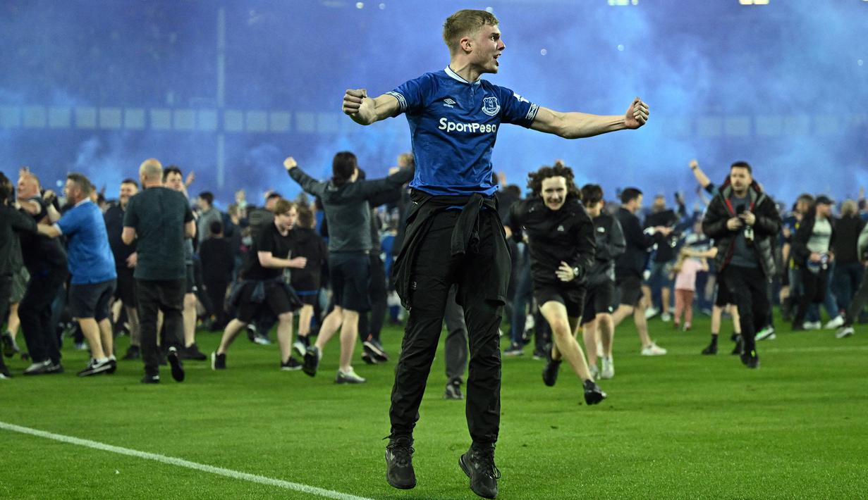 Suporter Everton menyerbu lapangan untuk merayakan akhir pertandingan Liga Inggris antara Everton dan Crystal Palace di Goodison Park di Liverpool, Inggris, 19 Mei 2022. Everton berhasil menang lewat come back dramatis 3-2 dan keluar dari zona degradasi Liga Inggris. (AFP/Oli Scarff)