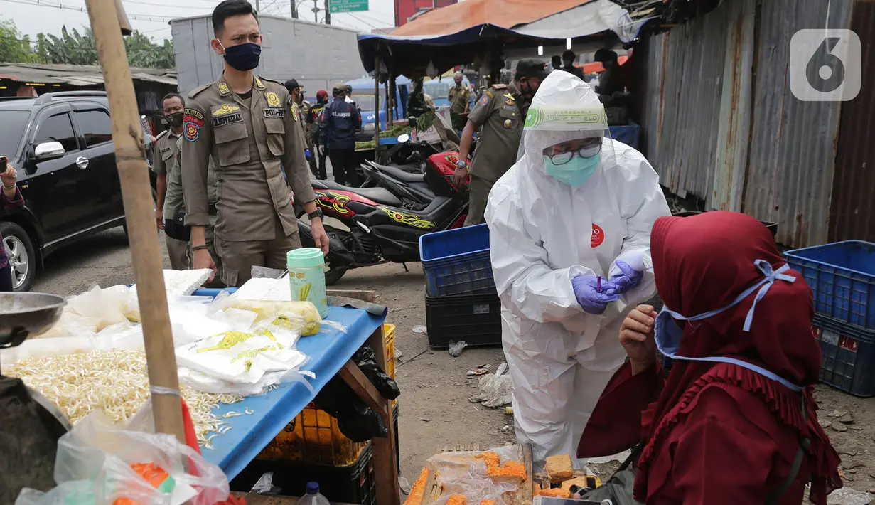 Petugas medis Gugus Tugas Kabupaten Bogor melakukan swab test dan rapid test kepada pedagang Pasar Cileungsi, Kabupaten Bogor, Jawa Barat, Selasa (16/6/2020). Para pedagang dengan sukarela ikut serta menjalani rapid test dan swab test. (merdeka.com/Imam Buhori)