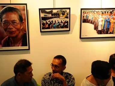 Pengunjung berbincang di depan deretan foto yang dipamerkan saat Peluncuran Buku Danau Toba dan Mangongkal Holi di Jakarta, Kamis (24/8). Pameran foto menampilkan kehidupan masyarakat dan budaya Batak. (LIputan6.com/Helmi Fithriansyah)