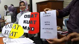 Pegawai MKD menunjukkan dokumen laporan dan simbolik obat kuat yang diberikan oleh sejumlah orangdari Indonesia Parlemen Watch (IP Watch) di Kompleks Parlemen, Jakarta, Kamis (24/11). (Liputan6.com/Johan Tallo)