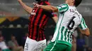 Pemain AC Milan, Gonzalo Higuain (kiri) berebut bola dengan pemain Real Betis Sergio Canales saat bertanding dalam Grup F Liga Europa di Stadion San Siro, Milan, Italia, Kamis (25/10). AC Milan kalah 1-2. (AP Photo/Antonio Calanni)