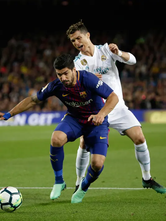 Pemain Barcelona, Luis Suarez dan pemain Real Madrid, Cristiano Ronaldo berebut bola pada pertandingan La Liga Spanyol di Stadion Camp Nou, Minggu (6/5). Real Madrid yang bermain dengan 11 pemain gagal mengalahkan 10 pemain Barcelona (AP/Emilio Morenatti)