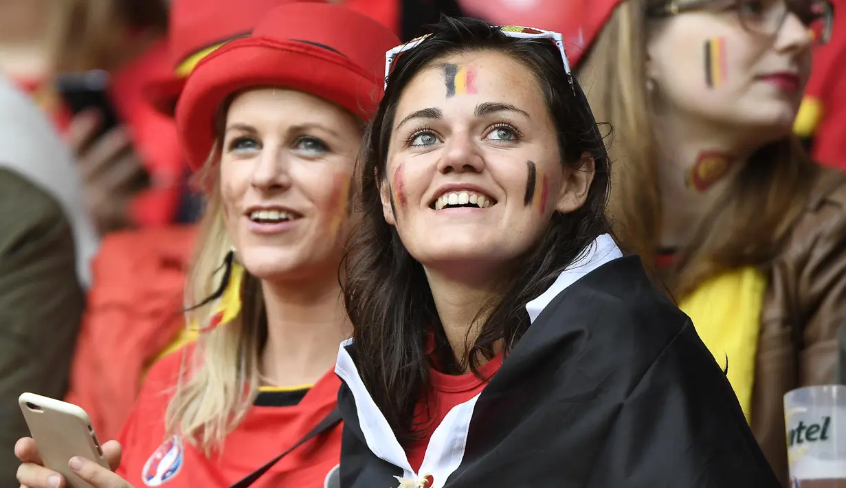 Fans cantik Belgia tengah serius menanti laga antara timnya melawan Wales pada perempat final Piala Eropa 2016 di Stade Pierre-Mauroy, Lille, Prancis, Sabtu (2/7/2016) dini hari WIB. (AFP/Miguel Medina)