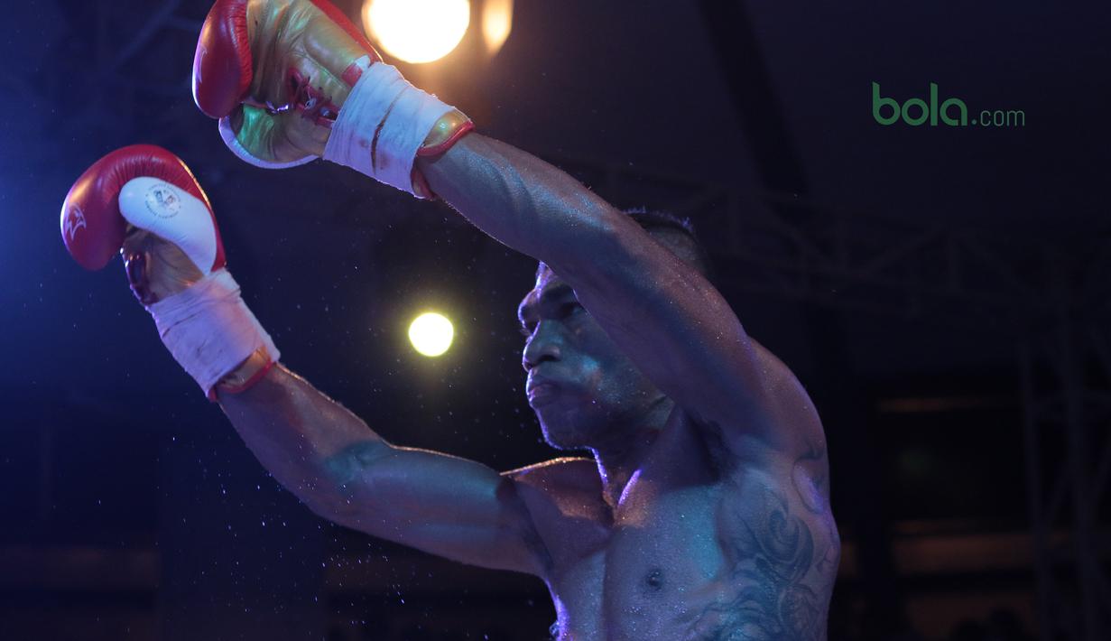 Jansen Marapu merayakan kemengan atas petinju Thailand, Phuttiphong Rakoon pada kelas Lightweight Mahkota Boxing Super Series di Cilandak Town Square, Jakarta (10/3/2018). Jansen menang TKO pada ronde ke sembilan. (Bola.com/Nick Hanoatubun)
