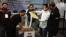 Panitia mengambil dokumen dari dalam kotak suara saat proses rekapitulasi penghitungan suara Pemilu 2019 tingkat Kota Jakarta Selatan di Hotel Maharaja, Jakarta, Selasa (7/5/2019). Proses penghitungan suara diselenggarakan selama tiga hari. (Liputan6.com/Herman Zakharia)