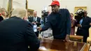 Rapper Kanye West menunjukkan foto pesawat hidrogen kepada Presiden AS, Donald Trump selama pertemuan di Oval Office, Gedung Putih, Kamis (11/10). West diundang untuk makan siang guna membahas reformasi penjara dan masalah lainnya. (AP/Evan Vucci)