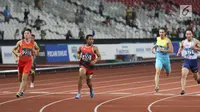 Pelari cepat Indonesia, Lalu Muhammad Zohri (tengah) usai kualifikasi lari 100 meter Asian Games 2018 di Stadion GBK, Jakarta, Sabtu (25/8). Lalu M Zohri mencatat waktu 10,27 detik dan berhak tampil di semifinal. (Liputan6.com/Helmi Fithriansyah)