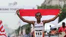Pelari Indonesia Agus Prayogo membawa Bendera Merah Putih usai melakukan trek maraton SEA Games XXIX di di Putrajaya, Kuala Lumpur, Malaysia, Sabtu (19/8). Agus berhasil meraih medali perak nomor lari marathon cabang atletik. (Liputan6.com/Faizal Fanani)