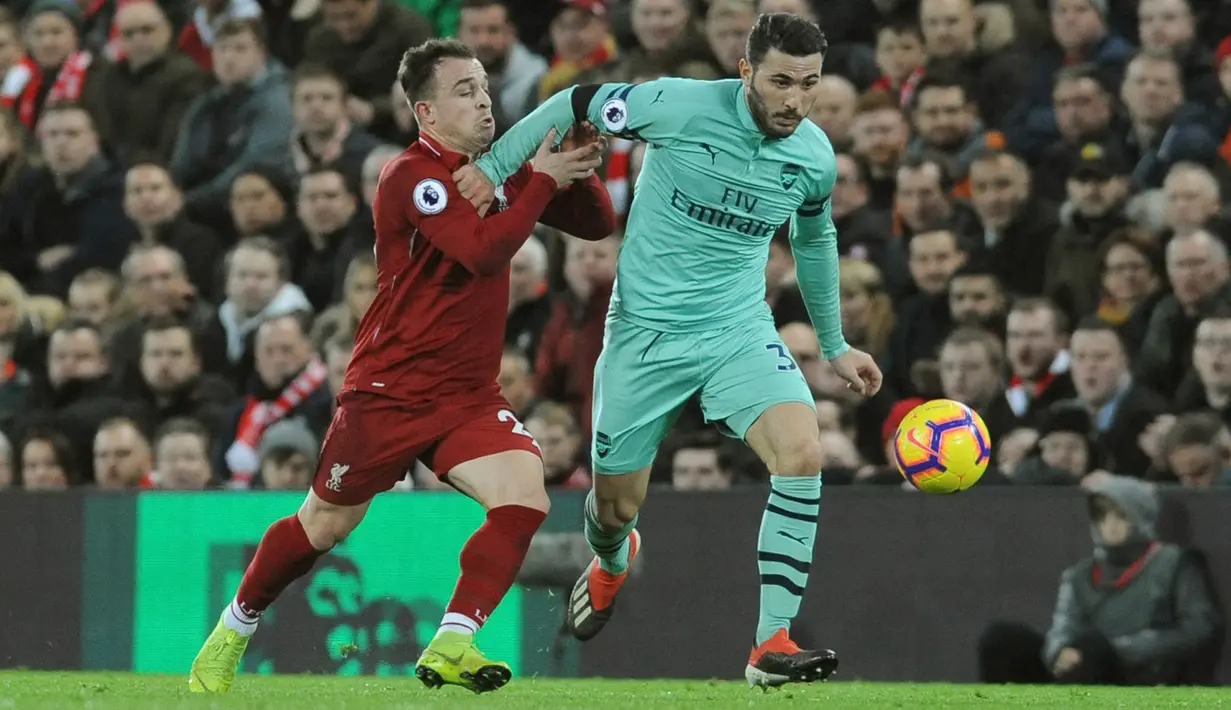 Gelandang Liverpool, Xherdan Shaqiri berusaha merebut bola yang dibawa bek Arsenal, Sead Kolasinac selama pertandingan lanjutan Liga Inggris di Anfield Stadium (29/12). Liverpool menang telak atas Arsenal 5-1. (AP Photo/Rui Vieira)