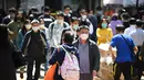 Orang-orang memakai masker di jalan di Hong Kong pada 27 Februari 2023. Perpanjangan mandat masker  tersebut menyeret terjadi saat kota tersebut akan menjadi tuan rumah sejumlah acara global, seperti turnamen golf World City Championship dan Museum Summit 2023, menjadikannya bulan tersibuk dalam lebih dari tiga tahun. (AFP/Peter Parks)