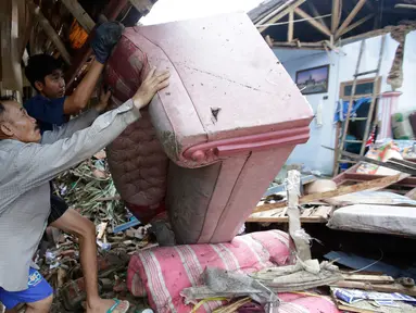 Warga lokal Alimin membersihkan puing-puing dari rumahnya setelah tsunami di Carita, Banten, Kamis, (27/12). Pemerintah telah memperluas zona larangan di sekitar pulau gunung berapi pulau yang memicu tsunami. (AP Photo/Achmad Ibrahim)