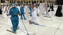 Pekerja mendisinfeksi area sekitar Kakbah untuk membantu menghentikan penyebaran virus corona COVID-19 saat umat muslim melaksanakan umrah di Masjidil Haram, Makkah, Arab Saudi, Minggu (30/5/2021). (AP Photo/Amr Nabil)