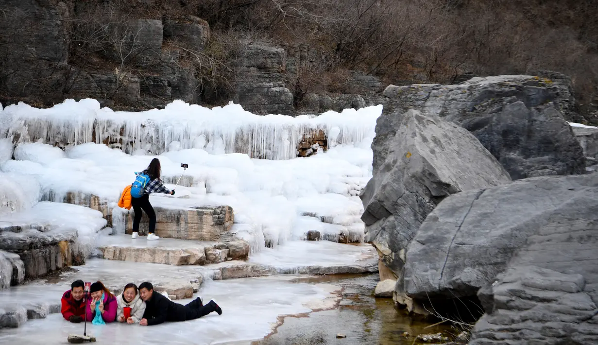 Sejumlah pengunjung menikmati pemandangan air terjun beku di objek wisata Gunung Yuntai di Jiaozuo, Provinsi Henan, China tengah, pada 24 Desember 2020. (Xinhua/Hao Yuan)