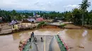 Selain jembatan yang putus, banjir juga merendam ratusan rumah warga di sepanjang aliran sungai Meureudu. Tampak foto udara menunjukkan jembatan yang rusak akibat banjir bandang di jalan utama yang menghubungkan Aceh dan Sumatera Utara di Meureudu, Kabupaten Pidie Jaya, Provinsi Aceh, pada Jumat 28 November 2025. (CHAIDEER MAHYUDDIN/AFP)