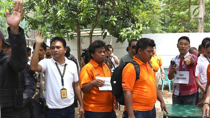 Tersangka IAW menjalani proses rekonstruksi Lapangan Tembak Senayan, Jakarta, Jumat (19/10). IAW menjalani 25 adegan rekonstruksi terkait dugaan enam peluru yang tertembak ke enam ruangan di Gedung DPR RI. (Liputan6.com/Immanuel Antonius)