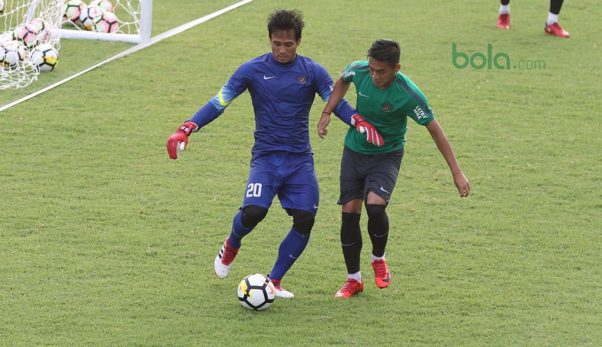 Kiper Timnas Indonesia U-23, Muhammad Ridho (kiri) membuang bola dari kejaran Septian David pada sesi latihan di Lapangan A,B,C, Senayan, Jakarta (18/2/2018). Latihan ini merupakan persiapan Asian Games 2018. (Bola.com/Nick Hanoatubun)
