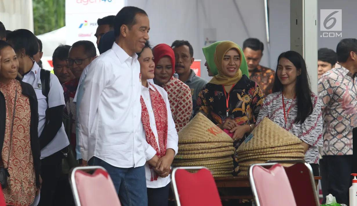 Presiden Joko Widodo didampingi Ibu Negara Iriana saat blusukan ke area persawahan untuk meninjau Gerakan Mengawal Musim Tanam Okmar 2018/2019 di Desa Leuwigoong, Garut, Jawa Barat, Sabtu (19/1). (Liputan6.com/Angga Yuniar)