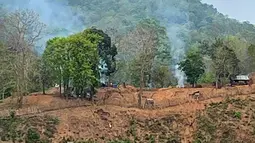 Kebakaran pangkalan militer Myanmar sepanjang tepi Sungai Salween terlihat dari Kota Mae Sam Laep, Provinsi Mae Hong Son, Thailand, Selasa (27/4/2021). Pemberontak etnis Karen mengklaim berhasil merebut pos militer Myanmar di perbatasan Thailand. (Handout/KAWTHOOLEI TODAY/AFP)