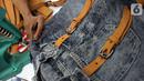 Perajin menyelesaikan pembuatan tas dari bahan celana jeans bekas di Legok, Tangerang, Banten, Senin (11/11/2019). Tas berbahan jeans itu dipasarkan ke kawasan Bandung serta pasar daring. (merdeka.com/Arie Basuki)